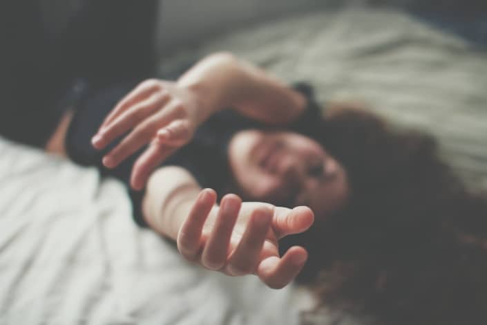 una foto borrosa de una mujer acostada extendiendo sus manos