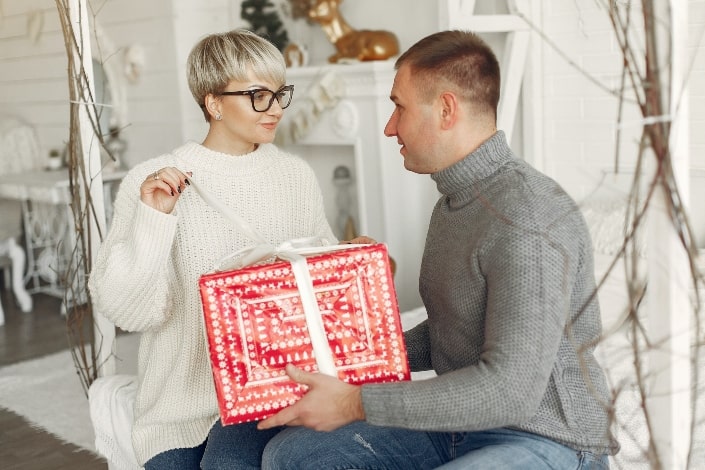 mujer abriendo su regalo de su hombre
