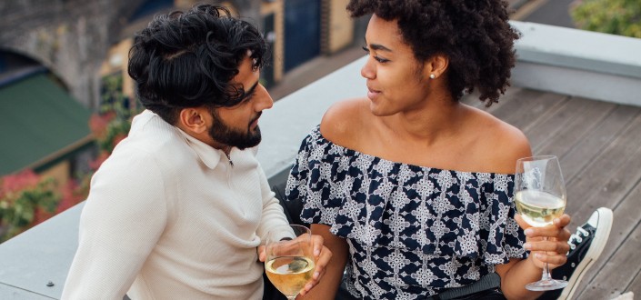 pareja romántica disfrutando del vino en una azotea