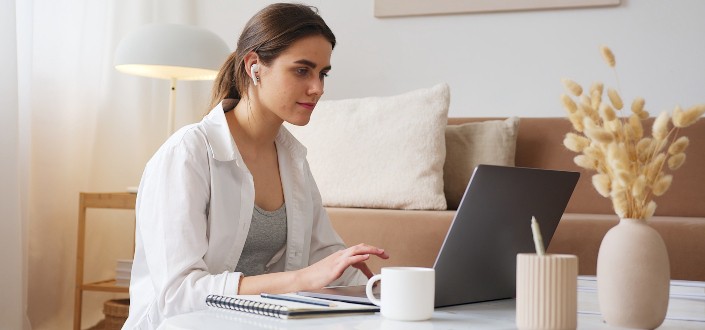 mujer en un headet trabajando con su computadora portátil