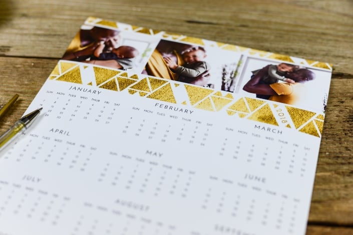 White and gold calendar on brown surface.