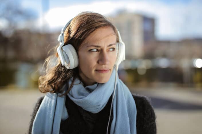 Mujer caminando mientras escucha música a través de sus auriculares